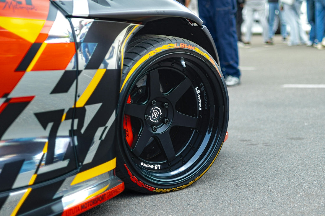 A race car's wheel with a black rim